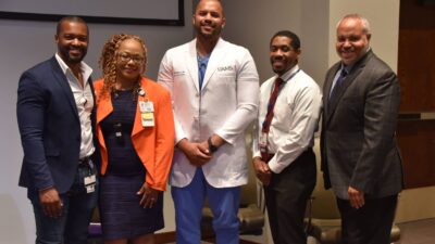 Adam Johnson (from left), M.D., Ph.D.; Sharanda Williams, M.A.; John Ukadike, D.O., MPH; Wayne Bryant Jr., M.D.; and William Greenfield, M.D., stand for a group photo after the Black Men in Medicine panel discussion.