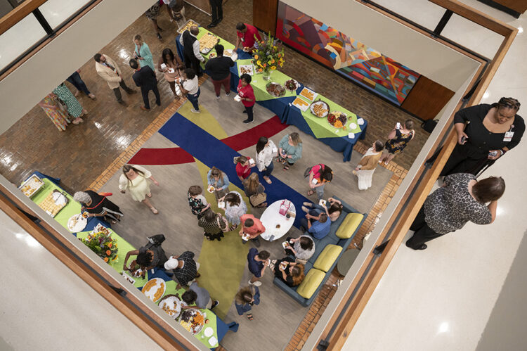 Seen from the third floor of the Administration West building, celebrants on the first floor mingle and dine on a brunch buffet. 