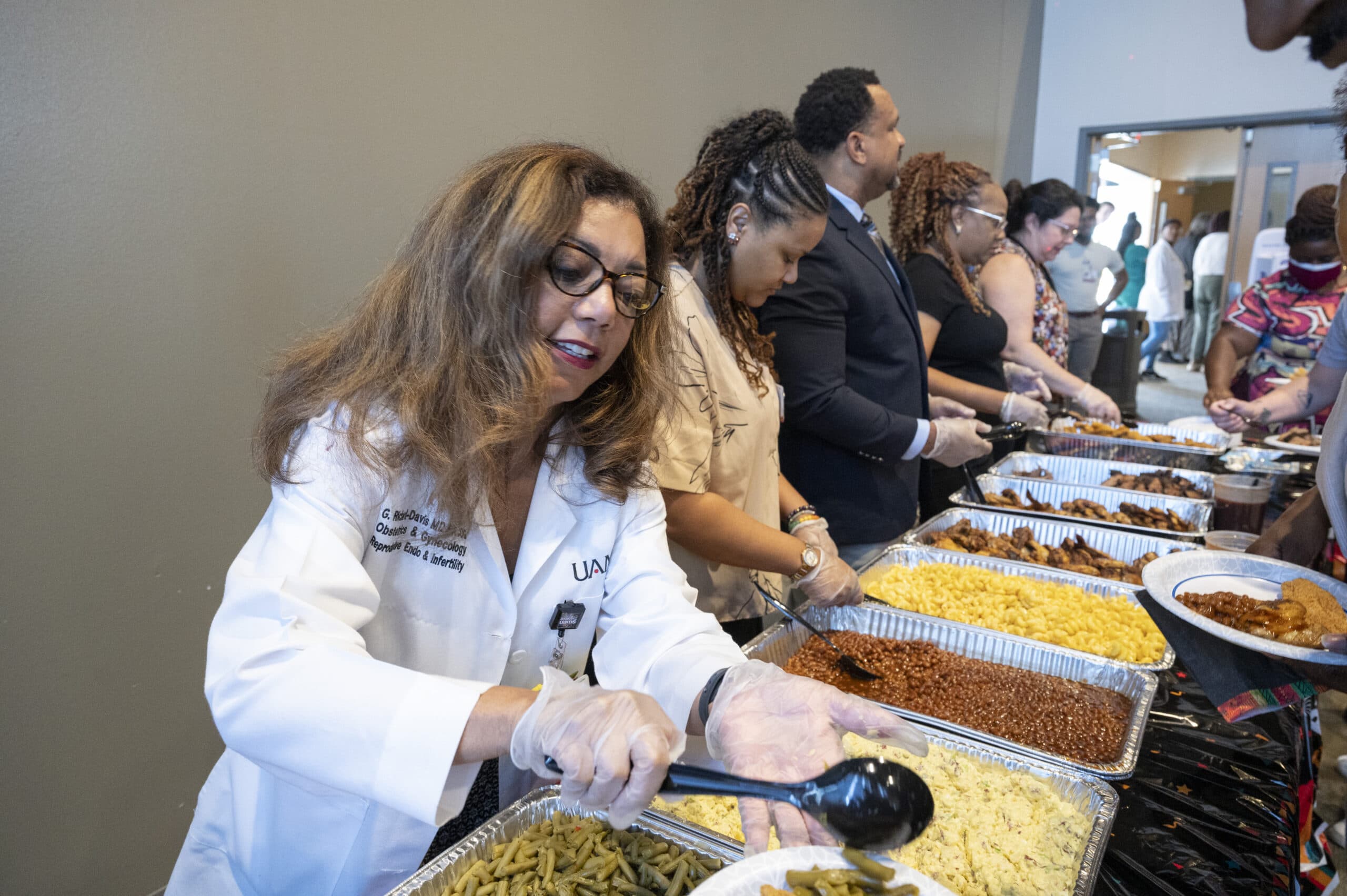 Gloria Richard-Davis, M.D., executive director of the UAMS Division for Diversity, Equity and Inclusion, serves food to staff and faculty members during the Juneteenth celebration.