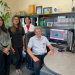 Vladimir Lupashin, Ph.D., at his desk surrounded by his team of graduate assistants. Standing from left to right: Amrita Khakurel, Farhana Taher Sumya and Zinia Dsouza