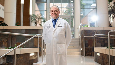 Dr. Michael Birrer standing in the lobby of the Winthrop P. Rockefeller Cancer Institute at UAMS