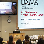 Dana Moser speaks and formally begins the Audiology & Speech-Language Pathology White Coat Ceremony in an auditorium of the I. Dodd Wilson Building on the UAMS Little Rock campus.