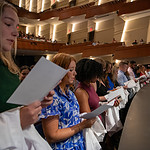 Incoming medical students, known as the Class of 2027, recite the medical student oath before donning their white coats on stage.