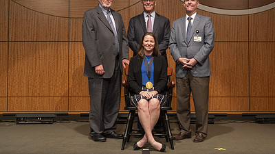 The University of Arkansas for Medical Sciences (UAMS) invested Julie Riley, M.D., (seated) in the Hal Reed Black, M.D., Chair in Urology. (Standing from left) G. Richard Smith, M.D., interim dean of the College of Medicine and UAMS executive vice chancellor; Timothy Langford, M.D., chair of the Department of Urology; and Cam Patterson, M.D., MBA, UAMS chancellor and CEO of UAMS Health.