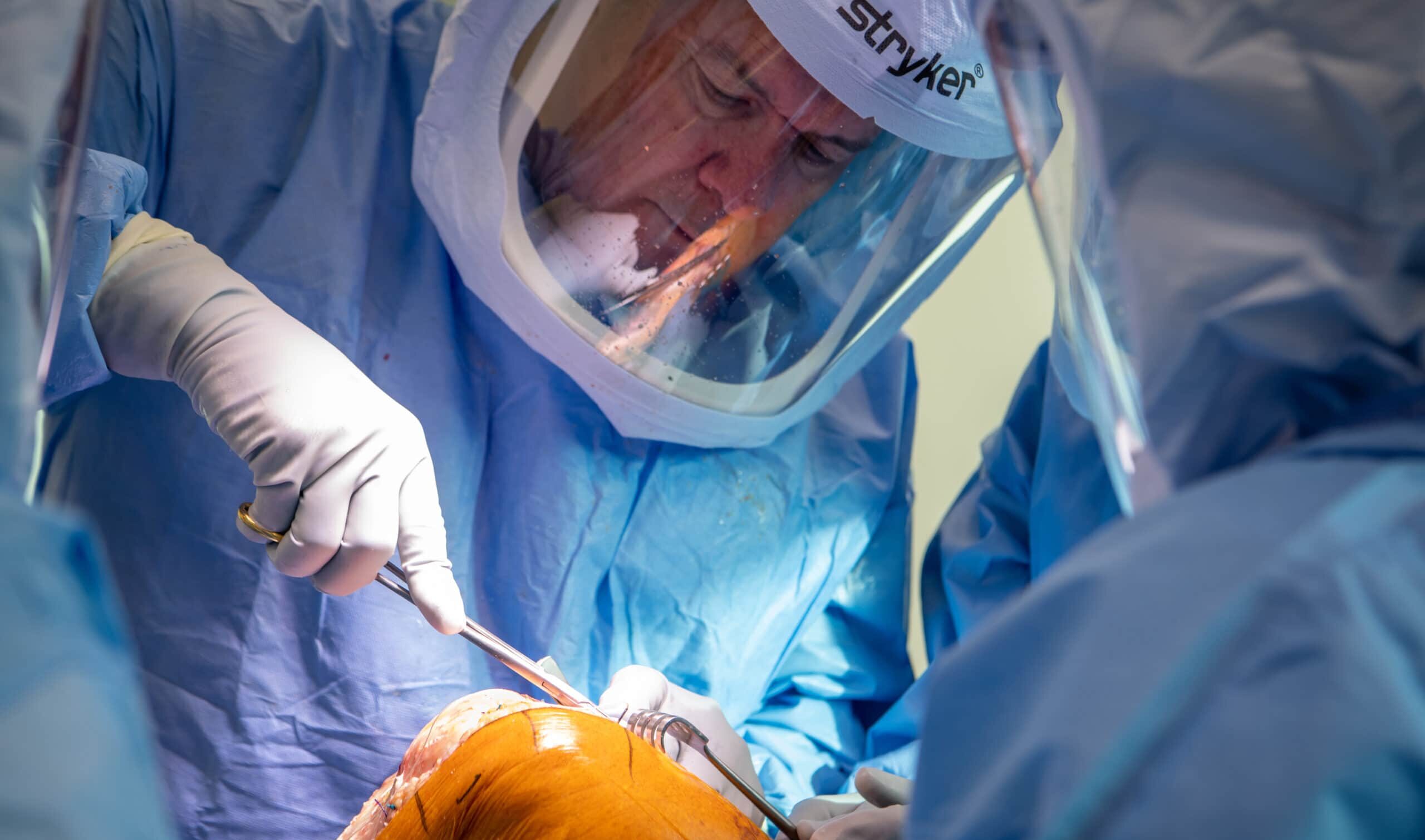 Lowry Barnes, M.D., performs a total knee replacement on his friend and colleague, Tom Frazier, M.D.