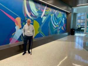 Frazier stands in front of a mural in the new surgical hospital three weeks after his total knee replacement.