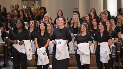 Students stand during the College of Nursing's white coat ceremony.