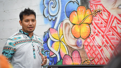 Artist Helmar Anitok talks about his mural during the unveiling in downtown Springdale.