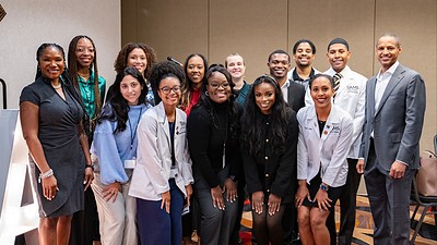 Standing group photo at the event. Among those attending the regional conference were (left to right, front row): Christy Walker, M.D., UAMS medical students Victoria Malak, Makenzie Henderson, Brianna Long, Kayla Jimmerson and Megan Clark, and Torrance Walker, M.D.; back row: medical students Raven Hinton, Andria Carter, Bree Dulaney, Jade-Michael Matthews, Evan Hicks, Quincy Gragg and Grant Broadway.