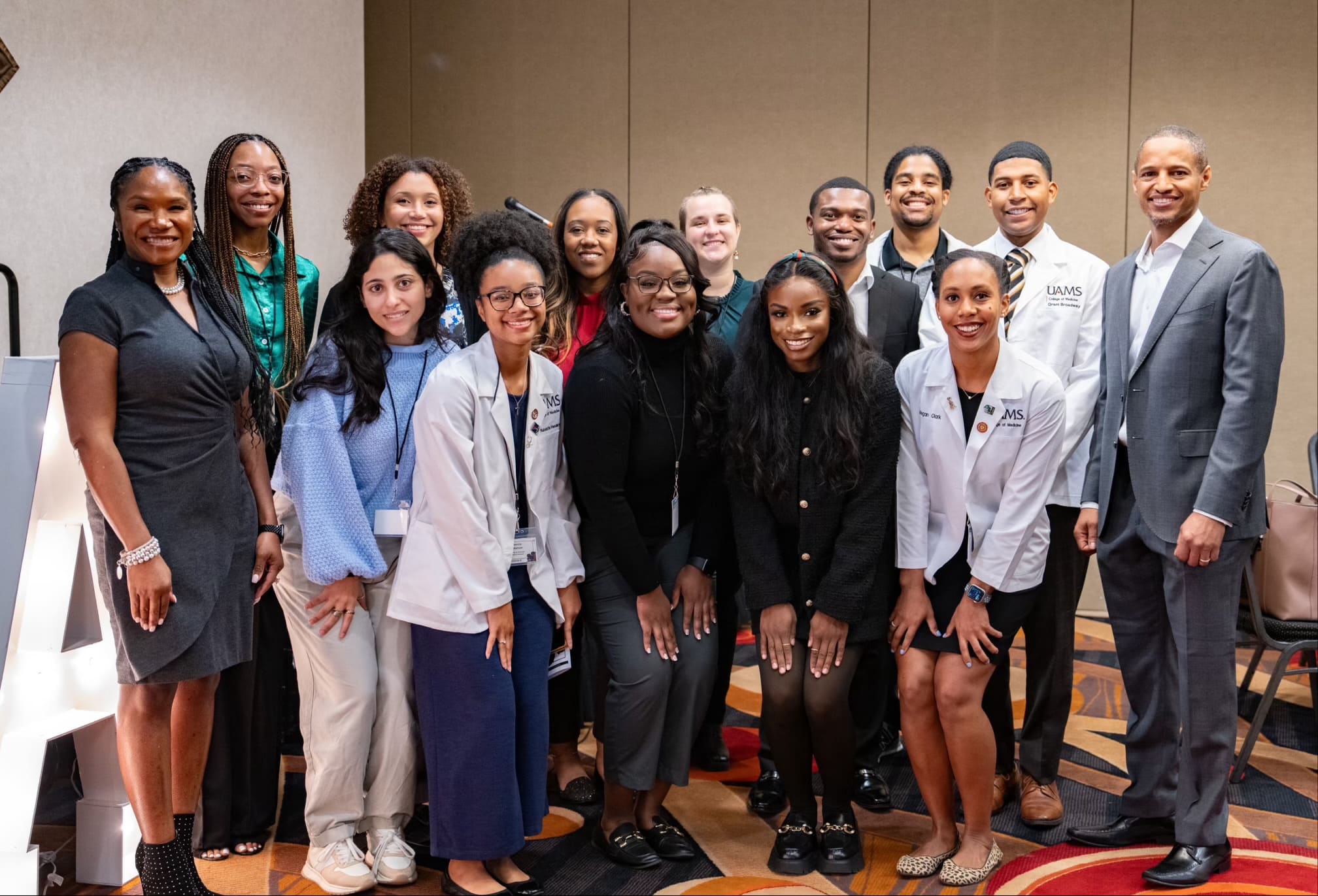 Standing group photo at the event. Among those attending the regional conference were (left to right, front row): Christy Walker, M.D., UAMS medical students Victoria Malak, Makenzie Henderson, Brianna Long, Kayla Jimmerson and Megan Clark, and Torrance Walker, M.D.; back row: medical students Raven Hinton, Andria Carter, Bree Dulaney, Jade-Michael Matthews, Evan Hicks, Quincy Gragg and Grant Broadway.