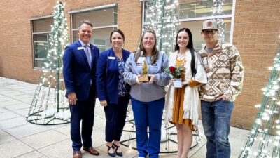 Reva Martin, center, holds the Willow Award presented to her moments before by Jeff Smith, left, Jodie McGinley. Dylan and Skye Billingsley, left, nominated her for the award. Courtesy of Jodie McGinley.