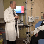 Dr. Michael Birrer speaks with a patient during a clinic visit