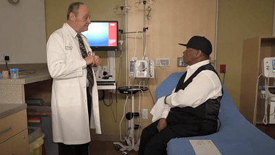 Dr. Michael Birrer speaks with a patient during a clinic visit