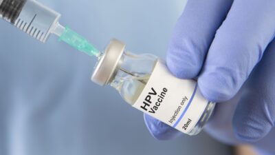 Needle pulling HPV vaccine from bottle