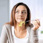 Woman looking thoughtful while eating