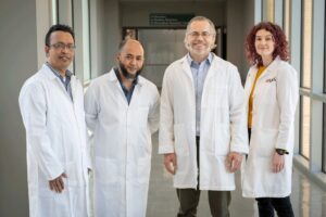 Four UAMS cancer researchers in white lab coats 
