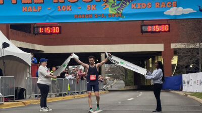 Robbie Kiss, fourth-year College of Medicine student, breaks the ribbon and finishes first March 3 in the Little Rock Half Marathon. Photo courtesy of the Little Rock Marathon