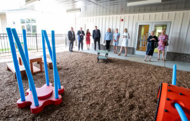 Visitors tour a covered activity area outside the UAMS Child Development Center.