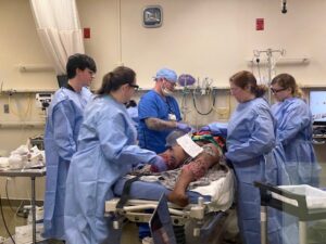 Interprofessional UAMS students are being monitored for stress as they attempt to stabilize the patient before transferring him to the operating room.