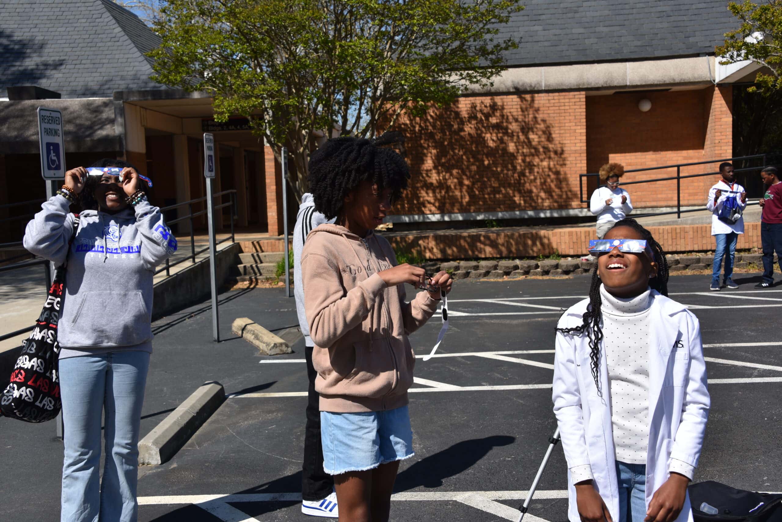 Pathways Academy scholars try out their eclipse glasses as they learn about how to safely view the sun.