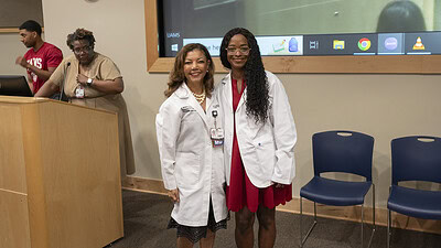 Natasha Wilhelm, a pre-med summer scholar, poses with Gloria Richard-Davis, M.D., in her newly presented white coat.