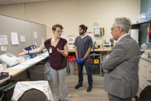 Rachel French, a third-year medical student, and Armin Mortazi, a lab volunteer, show College of Medicine Dean Steven Webber, M.D., around the 12th Street Health &amp; Wellness Center's lab facilities.
