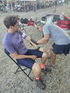 UAMS nurse gives first aid to a race participant in a chair.