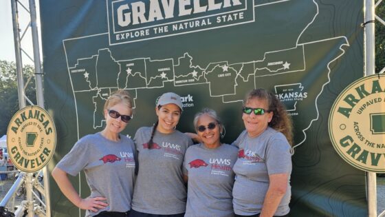 UAMS orthopaedics and sports medicine team members pose in front of the Arkansas Graveler map.
