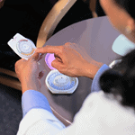 A health care worker points to a pill in a contraceptive box while speaking with a patient.