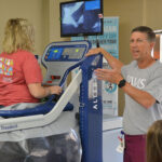 An instructor shows off a piece of physical therapy equipment