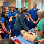 Students looking at a medical education mannequin