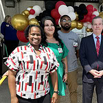 At the back of the Monroe Building and the entryway to the Stocked & Reddie Food Pantry, Katriel Alexander, left, Jennifer Mondragon, Christopher Guinn, Chancellor Cam Patterson and UAMS mascot Reddie celebrate the 5th anniversary of the establishment of the pantry.