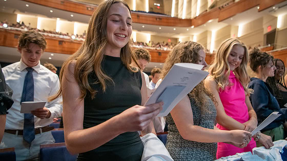 Students stand and read the medical student oath. Upper balconies in background.