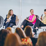 Members of a maternal health discussion panel speak to a crowd