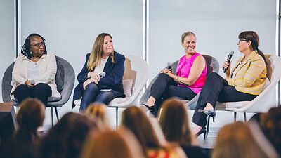 Members of a maternal health discussion panel speak to a crowd