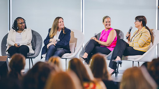 Members of a maternal health discussion panel speak to a crowd