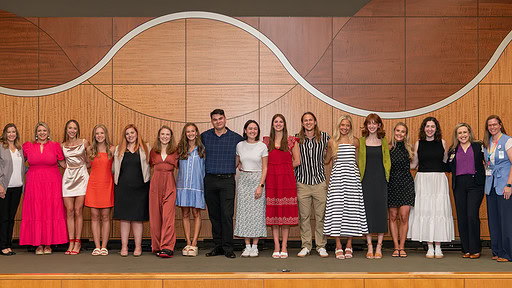 Class of 2024 graduates of the Master of Science in Dietetics Program take the stage in the Smith Auditorium and are joined by the department's faculty for a final class photo..