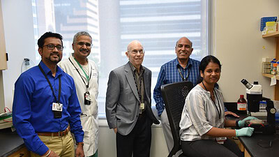 Researchers Meenakshisundaram Balasubramaniam (from left), Ph.D.; Srikanth Vallurupalli, M.D.; Robert J. Shmookler Reis, Ph.D.; Srinivas Ayyadevara, Ph.D.; and Akshatha Ganne are shown in their research laboratory at the UAMS Donald W. Reynolds Institute on Aging. Ganne was the lead author of the study published in the journal Aging Biology.