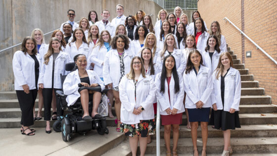 Along with faculty, students in the audiology and speech-language pathology programs gather for photo after the White Coat Ceremony.