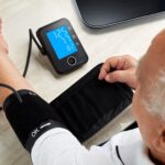 A man uses a remote monitor and blood pressure cuff