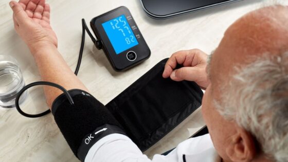 A man uses a remote monitor and blood pressure cuff