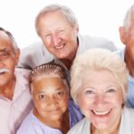 Five older adults pose for a photo in this stock image.