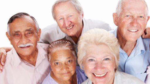 Five older adults pose for a photo in this stock image.