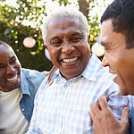 Three men are shown laughing in a garden in this stock image.