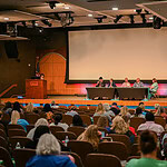 An audience of mostly health care professionals listens as stroke survivors share their experiences.