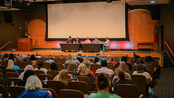 An audience of mostly health care professionals listens as stroke survivors share their experiences.