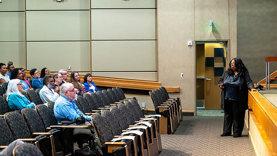 Harriet Washington stands in front of the stage in Smith Auditorium while discussing the history in the U.S, of racial health disparities.