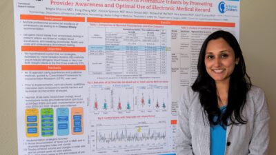 Megha Sharma, M.D., poses with a poster about her Implementation Science Scholars project.