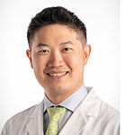 white-coat portrait-style photograph of Dr. Song with UAMS logo