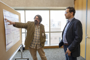 2 men discussing a poster presentation